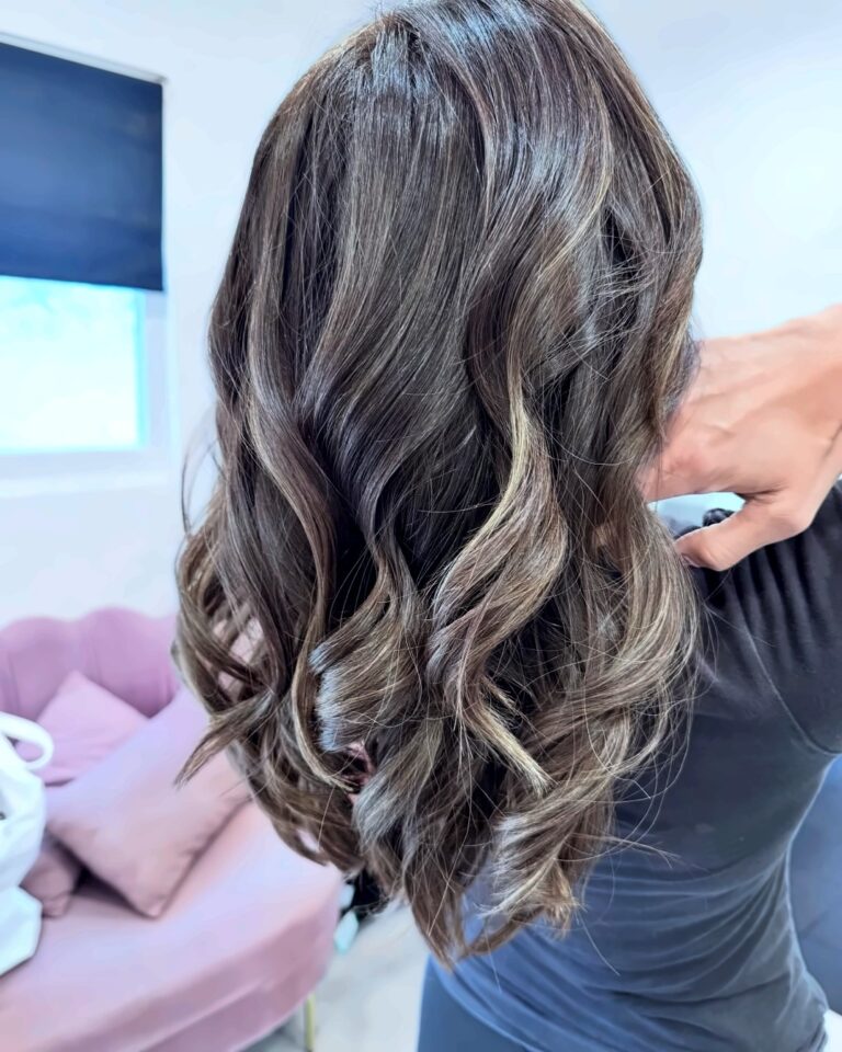 Shoulder-length ash brown balayage with loose curls